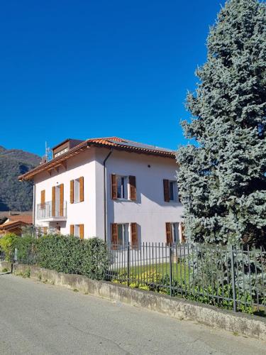 a white house with a fence next to a tree at LoSteLaDa sul lago di Como in Colico