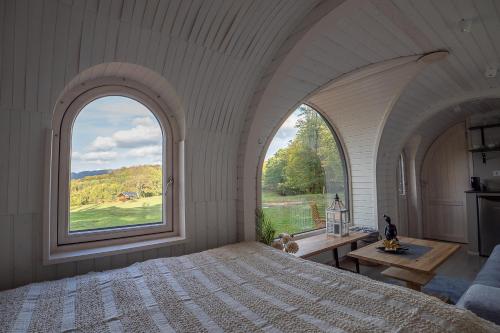 a bedroom with a large bed and a large window at Glamping Skrytín in Dobkovice