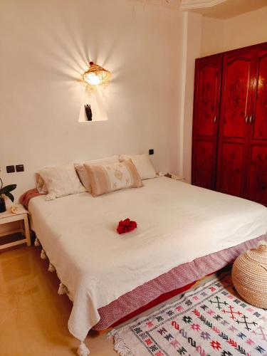 a bedroom with a large white bed with a red cabinet at Riad Noor in Agadir