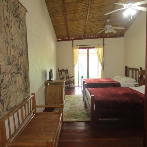 a bedroom with two beds and a ceiling at Hotel Lara's Planet in El Castillo de La Concepción