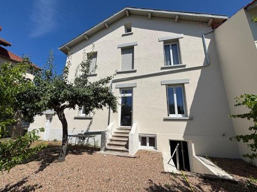 a large white building with a tree in front of it at Grand appartement avec piscine in Clermont-Ferrand