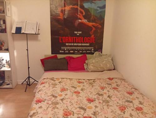 1 cama en una habitación con un póster de cine en la pared en Place Longchamps, en Marsella