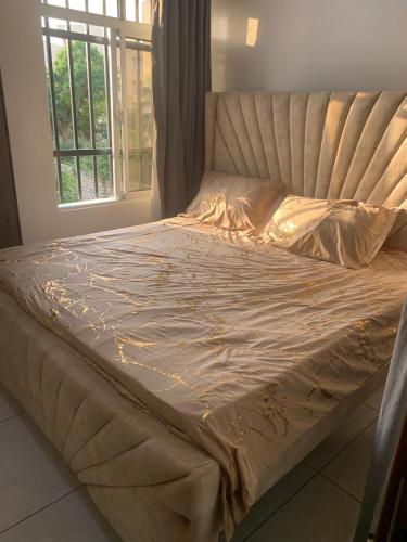 a large bed in a room with a window at Mtwapa behind mzuri sweet company in Mtwapa