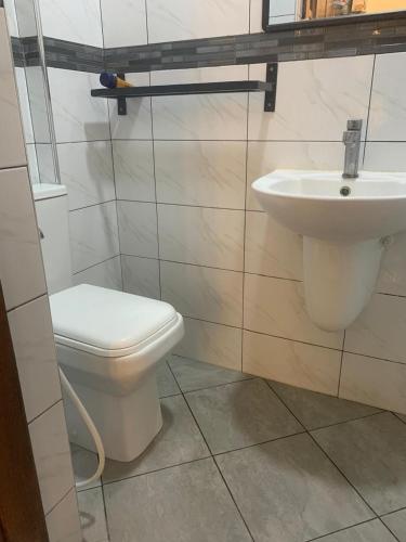 a bathroom with a toilet and a sink at Mtwapa behind mzuri sweet company in Mtwapa
