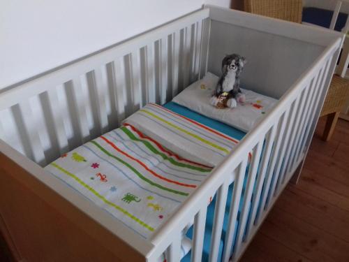 a stuffed dog sitting on a pillow in a crib at Ferienwohnung Wiesmühlstrasse in Henndorf am Wallersee