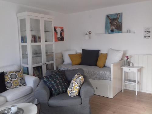 a living room with a couch and a dog picture on the wall at Ferienwohnung Wiesmühlstrasse in Henndorf am Wallersee