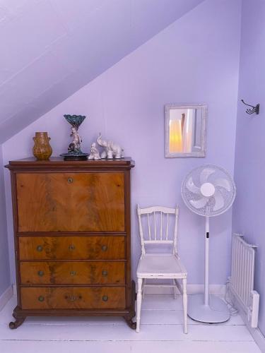 a room with a dresser and a chair and a fan at Björnåsen Bear Hill in Katrineholm