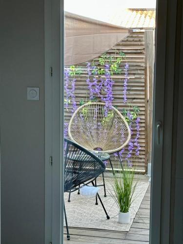 a patio with a bench and a wreath of purple flowers at Villa Evasion Soleil in Poussan