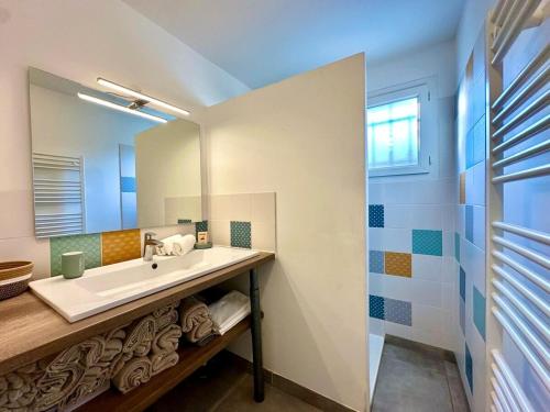 a bathroom with a sink and a mirror at Villa Evasion Soleil in Poussan