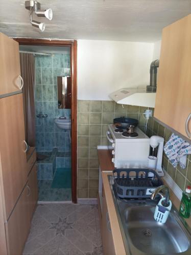 a small kitchen with a sink and a stove at The cave of Cyclops in Mákri