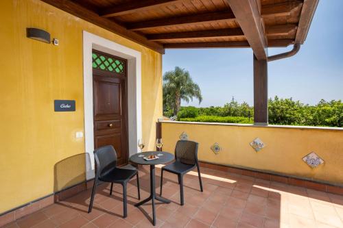 a patio with a table and chairs on a porch at Feudogrande Bio Relais Hotel in Fiumefreddo di Sicilia