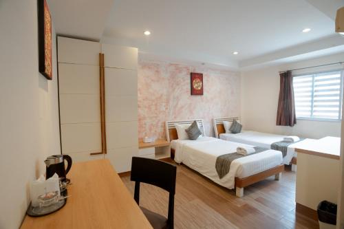 a hotel room with two beds and a table at My Way Hua Hin Music Hotel SHA Extra Plus in Hua Hin