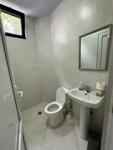 a bathroom with a toilet and a sink and a mirror at Hotel black sea in K'obulet'i