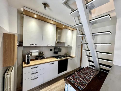 a kitchen with white cabinets and a spiral staircase at Cadriano House 
