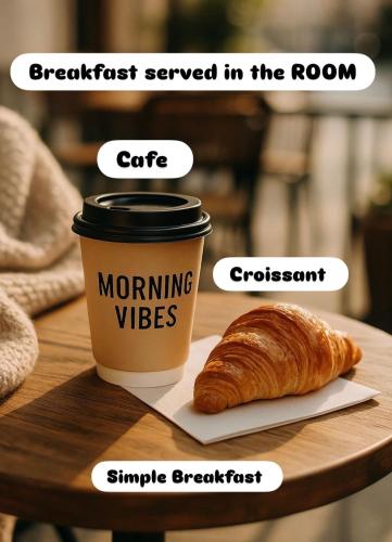 a cup of coffee and a croissant on a table at THE DOMI Apartments in Durrës