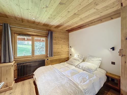 une chambre avec un grand lit dans une pièce aux murs en bois dans l'établissement Les Séracs, à Combloux