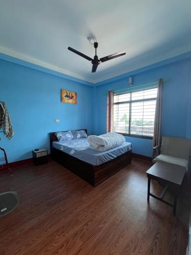 a bedroom with a bed and a ceiling fan at Hotel Atithi Devo Bhava in Lālbhitti