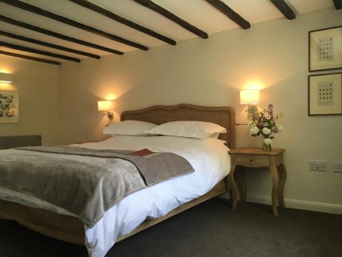 a bedroom with a large bed with white sheets and pillows at Penylan Barn in Hay-on-Wye