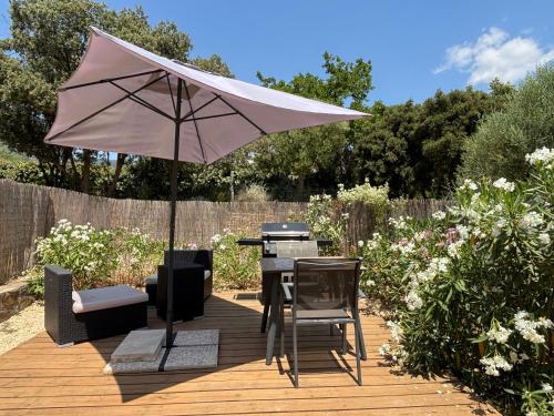 un patio avec un parasol, une table et des chaises dans l'établissement Le Plan de la Tour - Studio 2 pers climatisé, terrasse, parking, les olivades, au Plan-de-la-Tour