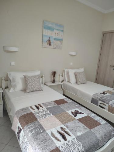 two beds sitting next to each other in a room at Vicky's Guesthouse in Kavos