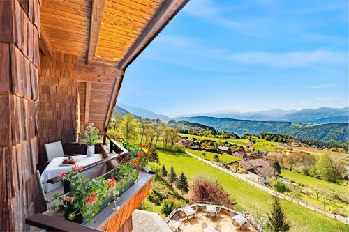 a view from the balcony of a house with flowers at Naturhotel Alpenrose in Millstatt