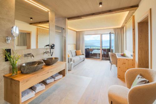 a bathroom with two sinks and a living room at Naturhotel Alpenrose in Millstatt