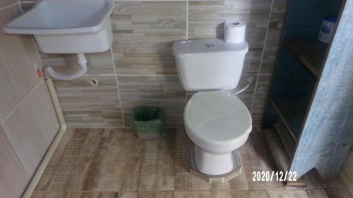 a small bathroom with a toilet and a sink at Estúdio Bambuzal no Centro in Alto Paraíso de Goiás