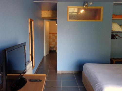 a bedroom with a bed and a tv in a room at Les ateliers du mont Bar in Allègre