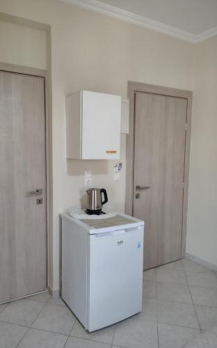 a kitchen with a refrigerator and a tea pot on a counter at Vicky's Guesthouse in Kavos