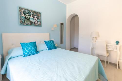 ein blaues Schlafzimmer mit einem Bett und blauen Kissen in der Unterkunft B&B Elysia in Lipari