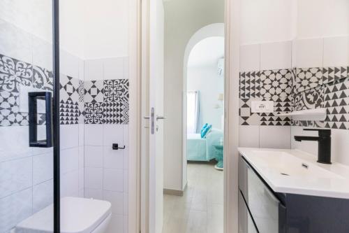 a white bathroom with a sink and a toilet at B&B Elysia in Lipari