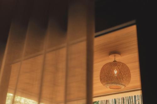 a pendant light hanging from a wooden door at Pousada Casa Mandacaru Noronha in Fernando de Noronha
