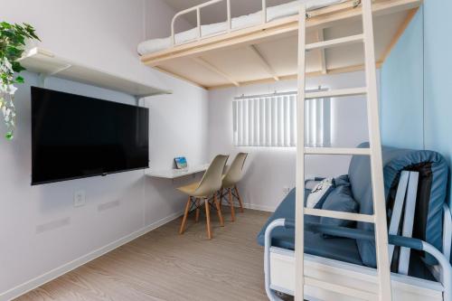 a bedroom with a bunk bed with a flat screen tv at 最大18名OK 南城市 百名の大型貸別荘 BBQ ビーチ近くでグループ滞在に最適 Seaside House Ichika in Nanjo
