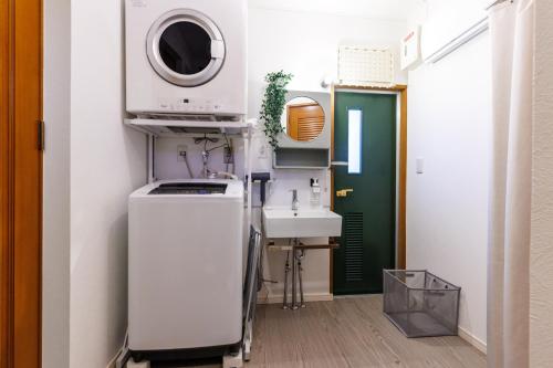 a kitchen with a sink and a microwave at 最大18名OK 南城市 百名の大型貸別荘 BBQ ビーチ近くでグループ滞在に最適 Seaside House Ichika in Nanjo