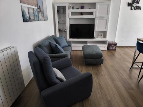 a living room with two couches and a tv at Casa del Sol in Leporano