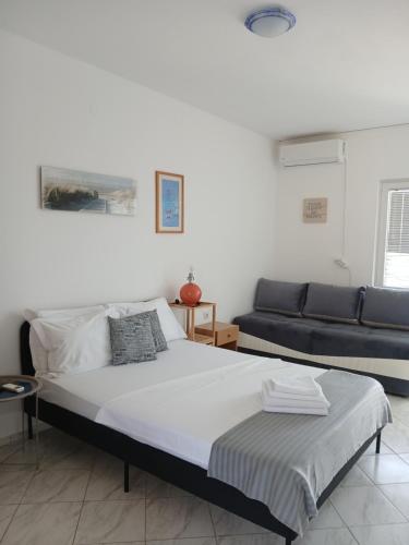 a bedroom with a bed and a couch at vila Rosmarin in Dobra Voda