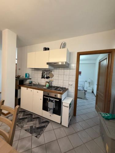 a kitchen with white cabinets and a stove top oven at The Happy Place Montecatini in Montecatini Terme