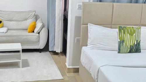 a room with a bed and a couch and a chair at Nakuru city classic studio in Nakuru