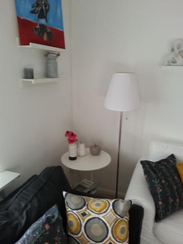 a living room with a couch and a table with a lamp at Ferienwohnung Wiesmühlstrasse in Henndorf am Wallersee