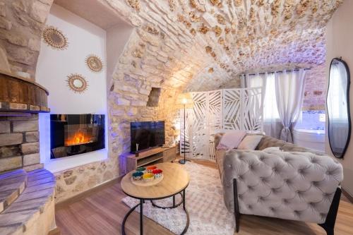 a living room with a couch and a fireplace at Sous les voûtes in Gargenville