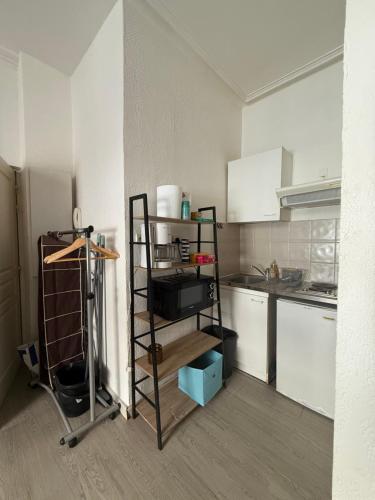 - une cuisine avec une étagère dans le coin d'une pièce dans l'établissement Le studio des carmes, à Nîmes