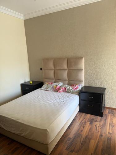Un dormitorio con una cama grande con dos mesitas de noche. en Savannah beach, en Dar Hamida