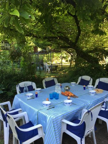 a table with a blue and white table cloth and chairs at Villa des glycines et Spa in Cempuis