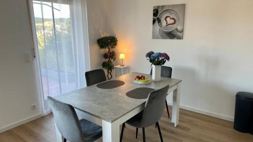 a dining room with a table with chairs and a vase of flowers at Ferienwohnung Panoramablick in Erbach im Odenwald