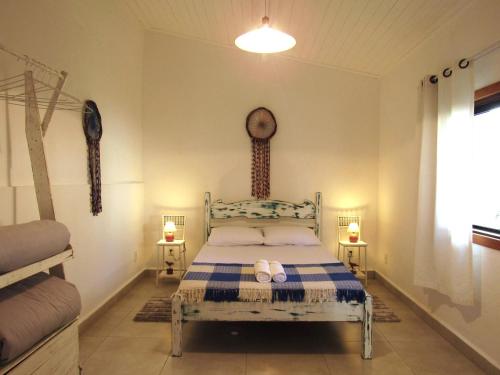una camera da letto con un letto, due lampade e una finestra di Suíte Alvorada Tiradentes MG a Tiradentes