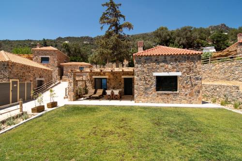 an exterior view of a stone house with a yard at Aoria Villas in Palaiochóra