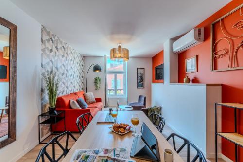 un salon avec une table, des chaises et un canapé dans l'établissement T2 Dahlia Roanne centre-ville - Parking & Clim, à Roanne