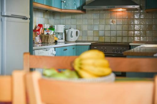 a kitchen with a bunch of bananas on a table at Liakoto Villa with private pool and jacuzzi in Makry Gialos