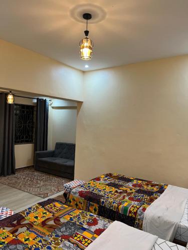 a living room with two beds and a couch at Kivuli Inn in Moshi