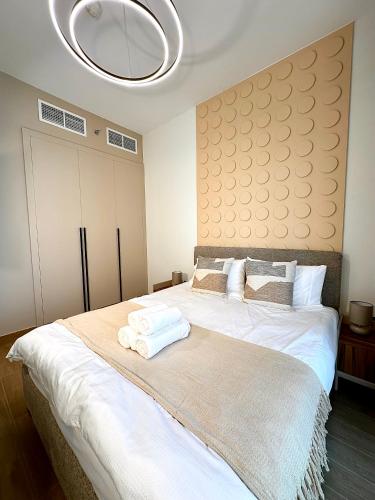 Un dormitorio con una gran cama blanca con una lámpara de araña. en Comfortable 1 Bedroom with Balcony Vista 1, en Abu Dabi